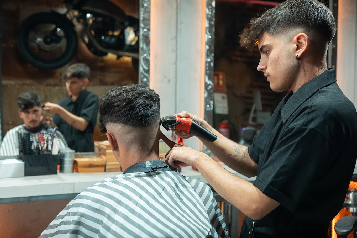 Barbero realizando un corte de cabello moderno con maquinilla en The Original Barber Shop.